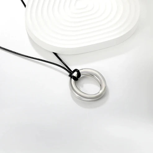 Collar Olivia para mujer en forma de aro con cadena cordón de cuero natural PU color negro. Collar de diseño contemporáneo con un aro entrelazados que aportan un estilo moderno y sofisticado