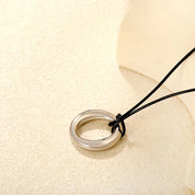 Collar Olivia para mujer en forma de aro con cadena cordón de cuero natural PU color negro. Collar de diseño contemporáneo con un aro entrelazados que aportan un estilo moderno y sofisticado